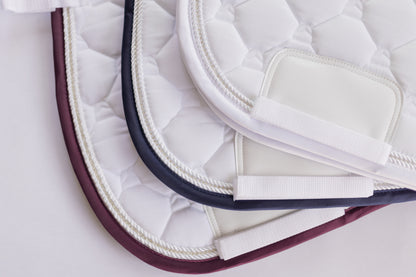 three jumping saddle pad colors including merlot maroon, navy blue, and white