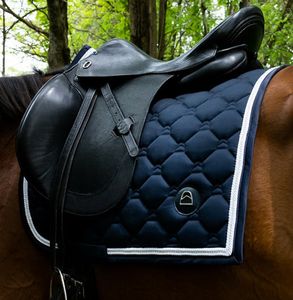 navy dressage saddle pad with crystals on bay horse and black dressage saddle and white trim